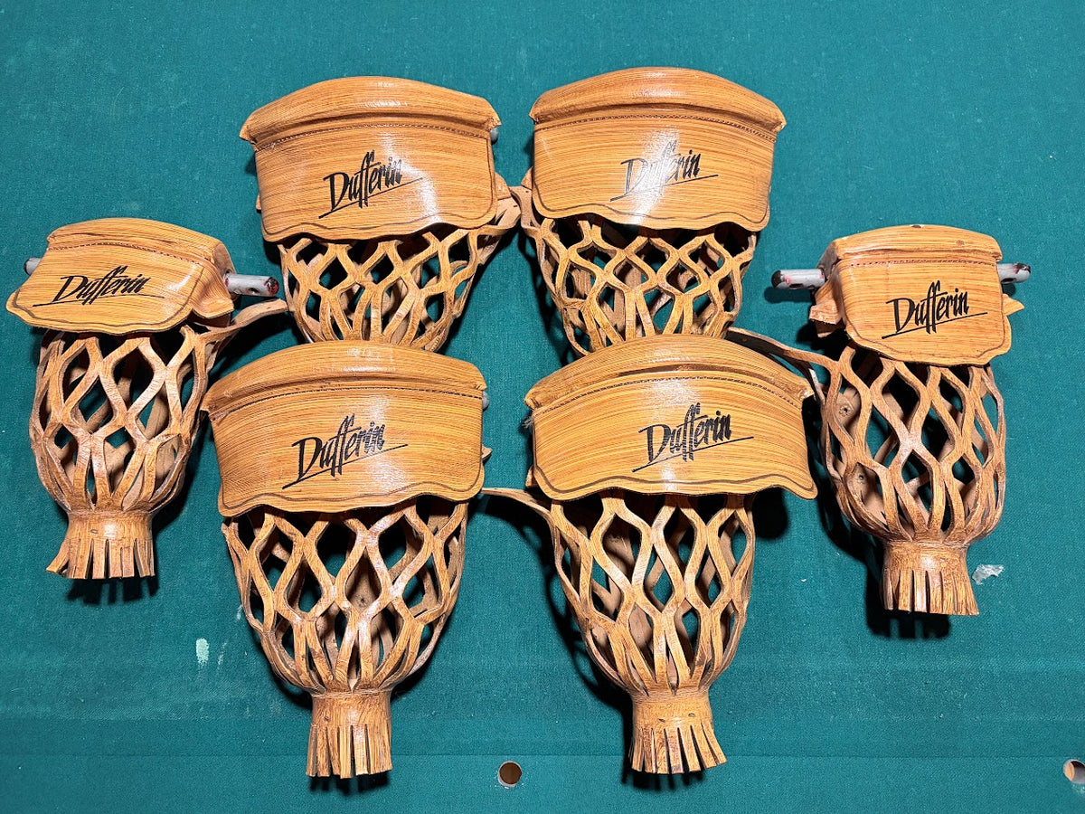 Six handcrafted wooden lacrosse sticks with woven netting and the brand name 'Duffrin' engraved on the wooden cup, arranged on a teal felt surface.