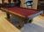 8' PREOWNED DUFFERIN ROYAL POOL TABLE INSTALLED WITH ACCESSORIES. WALNUT FINISH