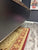 Close-up of a textured surface with a rug and floor visible in the background