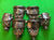 Six black leather and metal hockey gloves arranged on a bright green background.
