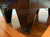 Close-up of a dark wood pool table leg with decorative carved panels and brass-colored ring pulls on a hardwood floor.
