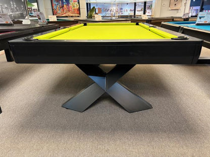 Pool table with a green felt surface in a room with other tables and equipment.