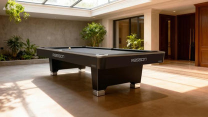 Pool table in a well-lit room with plants and wooden doors.