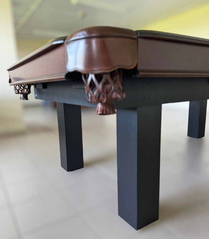 The corner view of Majestic Orleans 7-foot walnut frame and black square legs pool table with leather drop pockets 