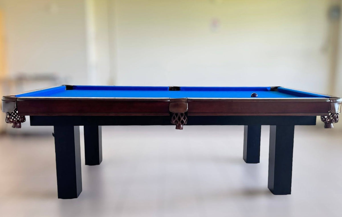 The side view of Majestic Orleans 7-foot walnut frame and black legs pool table with leather drop pockets and blue felt 
