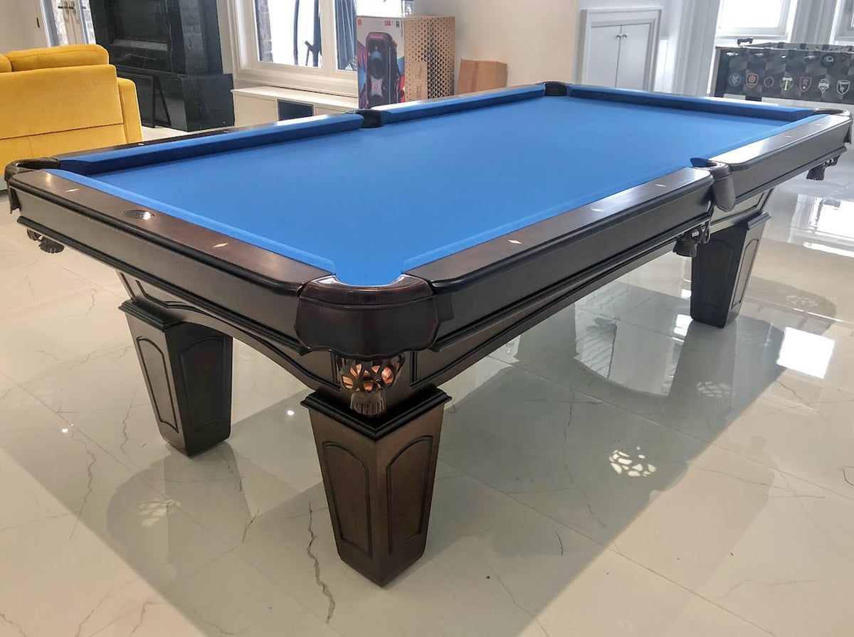 The angle view of the Majestic Ascot 7-foot walnut pool table with leather drop pockets and slate playing surface with blue cloth