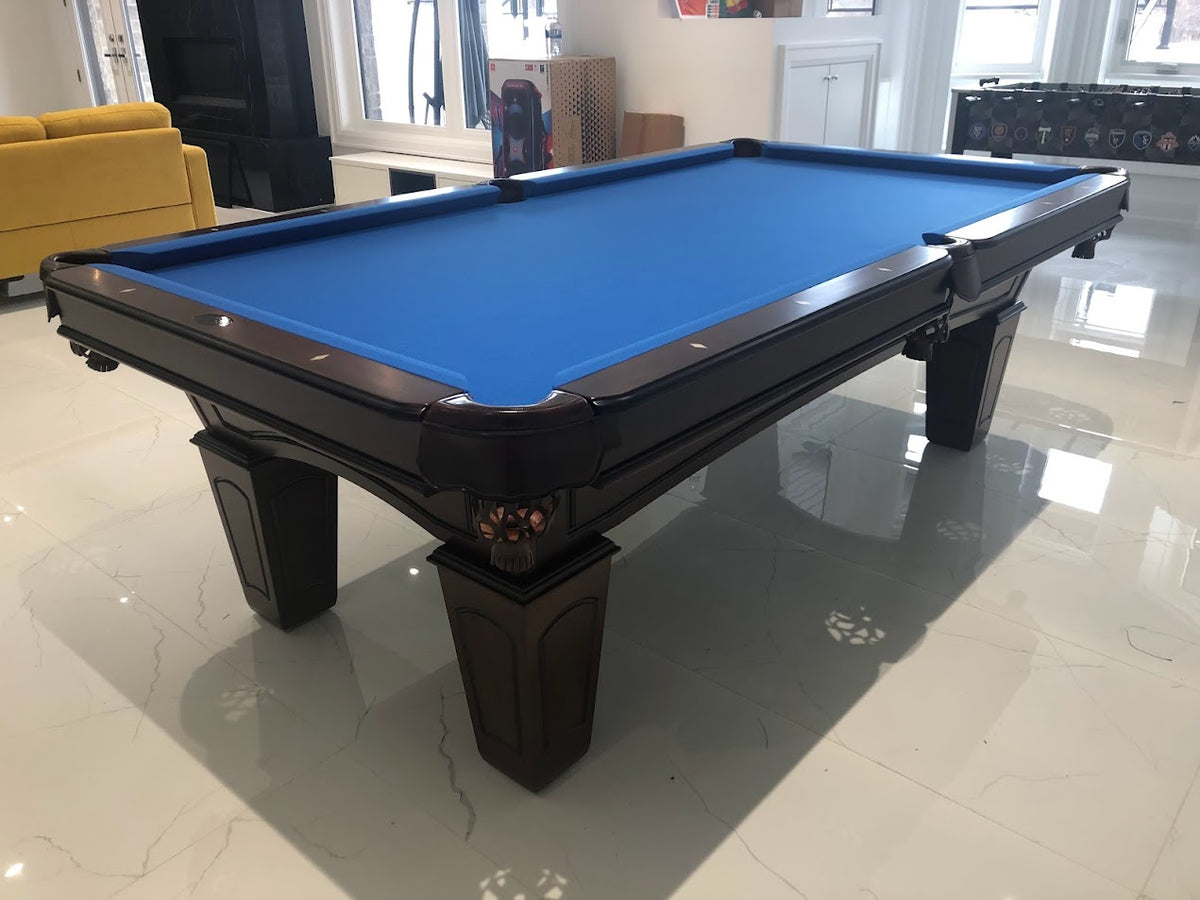 The full view from corner of the Majestic Ascot 7-foot walnut pool table with leather drop pockets and blue fabric playing surface