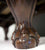 The brown wood pool table leg in the shape of claw holding the billiard ball