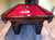 A 9' Majestic Ascot Walnut Pool Table with a red felt , walnut wooden frame and legs, and ball and cue placed on the table.
