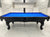 A black 8' Majestic Amboise pool table with blue cloth, featuring a classic design with ornate legs and a sleek finish.