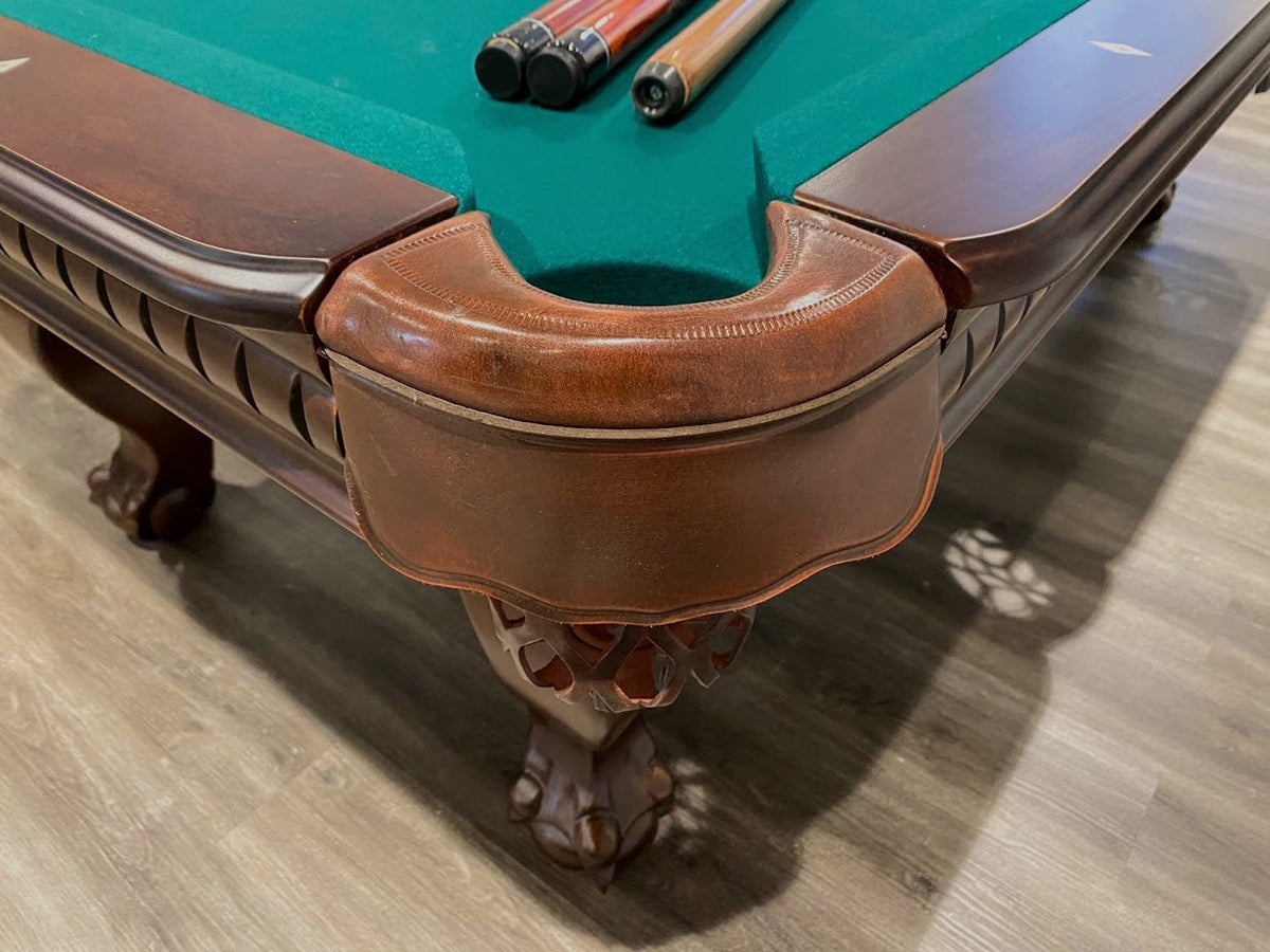 Pocket of maple finish pool table with claw leg