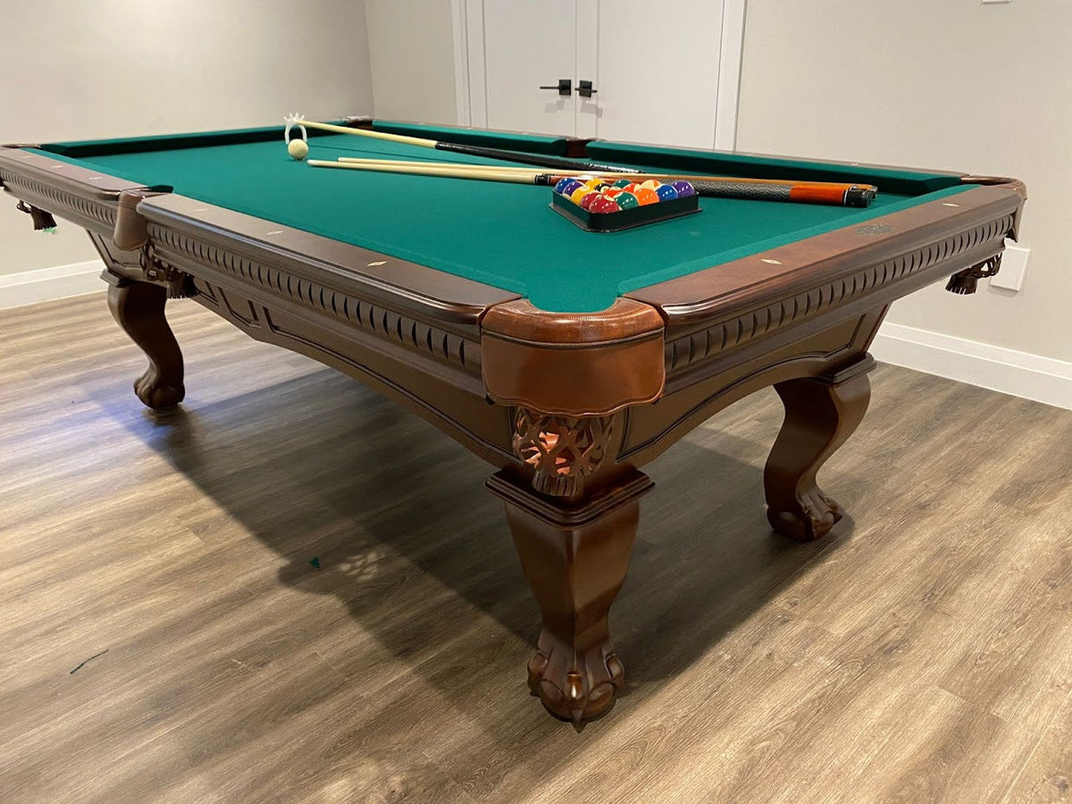 Corner view of the Majestic Pinnacle 7-foot walnut pool table with leather drop pockets, green felt and billiard accessories