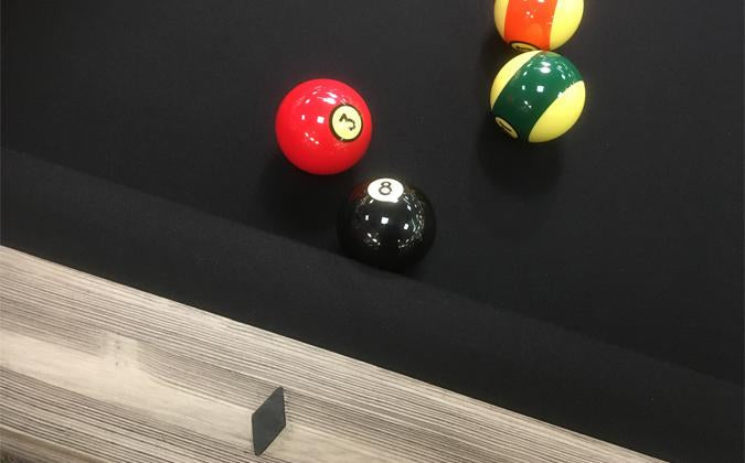 The  view of the Mensa 7-foot barn wood modern pool table rail and billiard balls